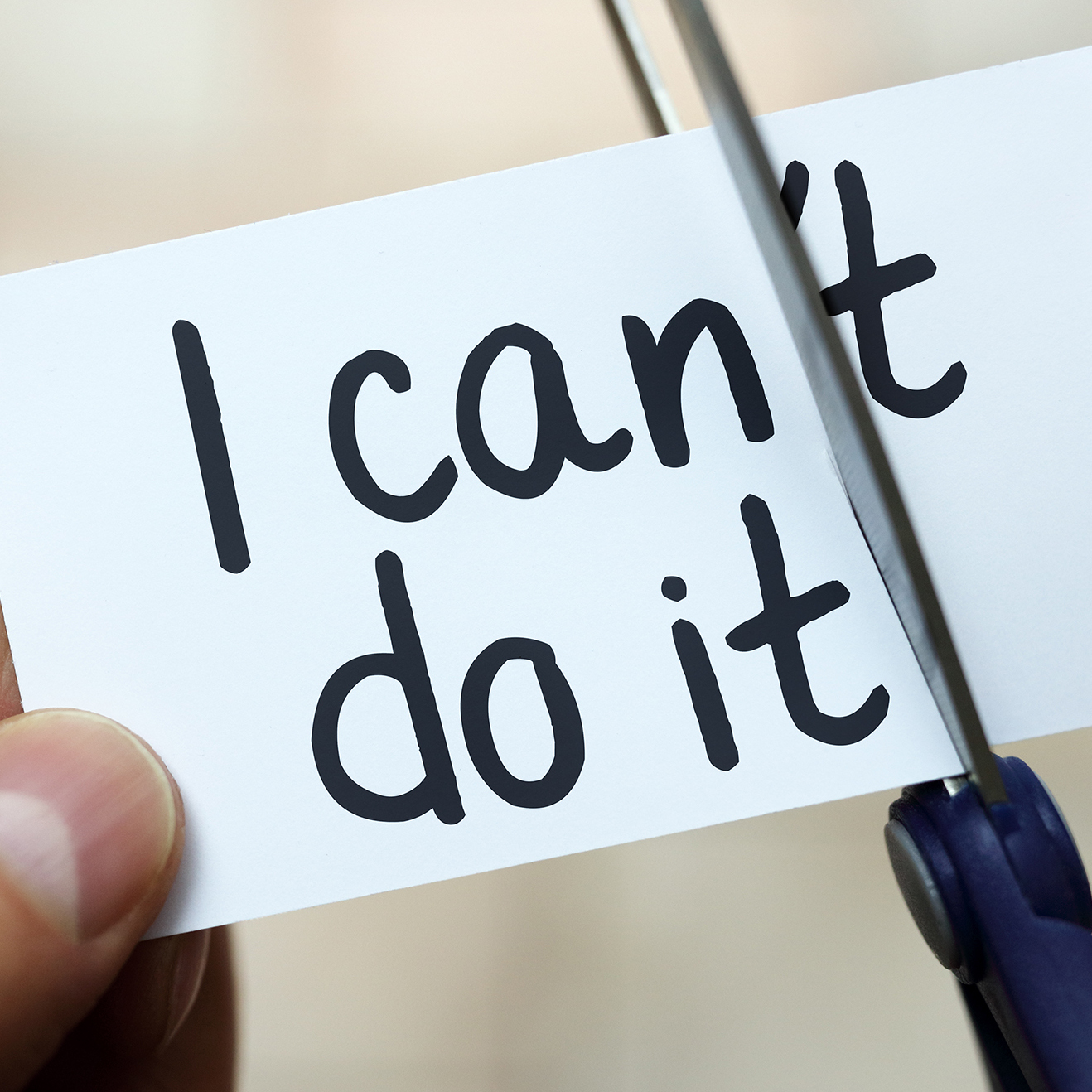 Man using scissors to remove the word can't to read I can do it concept for self belief, positive attitude and  motivation